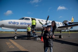 Mother And Son Smiling In Front Of The Airplane